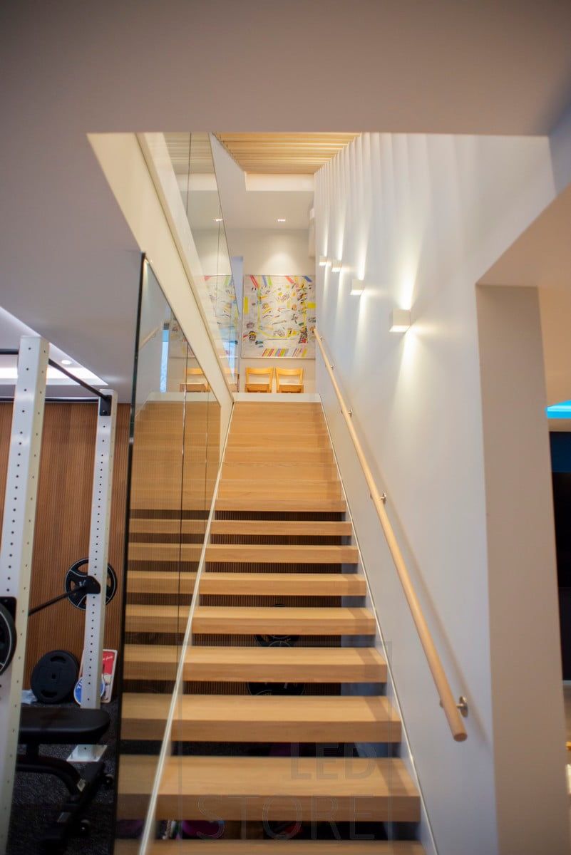 CUBIC wall lights illuminating the staircase, led strips in the flush profile illuminate from above. Line 5 luminaire highlighting the table.